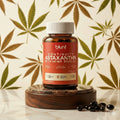 Bottle of Blunt Astaxanthin with Hemp Seed Oil on a wooden stand with a cannabis leaf pattern in the background